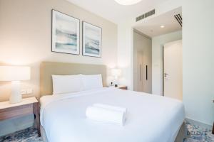 Ένα ή περισσότερα κρεβάτια σε δωμάτιο στο Seafront 4BR Apartment with Assistant Room in The Address Fujairah Residences Block B, Fujairah by Deluxe Holiday Homes