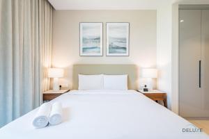 Ένα ή περισσότερα κρεβάτια σε δωμάτιο στο Seafront 4BR Apartment with Assistant Room in The Address Fujairah Residences Block B, Fujairah by Deluxe Holiday Homes