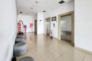 a hallway of a building with chairs and doors at RedLiving Apartemen Enviro Cikarang - Stars Rooms in Cibeber
