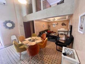 una sala de estar con una mesa y sillas en Au Riad des Deux Patios - Marrakech, en Marrakech
