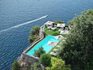 an aerial view of a pool with umbrellas and the water at Hotel Piccolo Sant'Andrea in Praiano