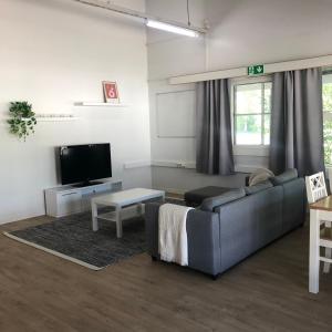 a living room with a couch and a tv at Pohjoiskeskus 9 in Oulu