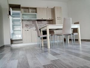 a kitchen with a table and chairs and an open refrigerator at Villa Chirilú in Polignano a Mare