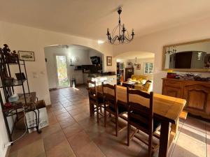 La pinède, 8 couchages vaste terrain piscine في Garéoult: غرفة طعام ومطبخ مع طاولة وكراسي