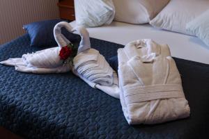 un letto con due asciugamani sopra con una rosa di Hotel Zagi a Oroslavje