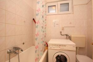 a bathroom with a washing machine in a bath tub at Apartmány Viktor in Selca kod Bogomolja +36 photos