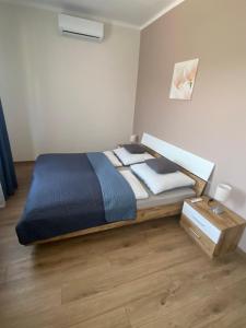 a bedroom with a bed with a blue comforter at AZUR Apartments Alsóörs in Alsóörs
