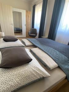 a bedroom with two beds with pillows and a mirror at AZUR Apartments Alsóörs in Alsóörs