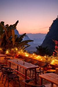 a group of tables and chairs with lights at Yangshuo Yunshe Mountain Guesthouse in Yangshuo