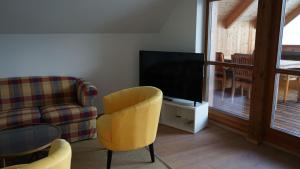 a living room with a tv and a couch and a chair at Ferienwohnung SeeTraum Hallstatt in Hallstatt