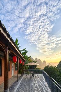 a patio with a table and an umbrella at Yangshuo Yunshe Mountain Guesthouse in Yangshuo