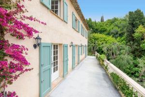 a corridor of a building with blue doors and flowers at Bastide Provençale,Piscine in Cabris
