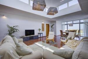 a living room with a white couch and a tv at Vila Al Mar in Caleta De Fuste