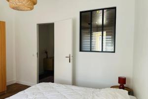 a bedroom with a white bed and a window at La Hourdeloise appartement 100m de la mer à Cayeux in Cayeux-sur-Mer