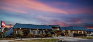 蒂默特Amaroo Motel Tumuts Best Accommodation的多云天空下的蓝色屋顶建筑