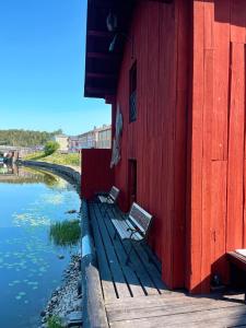two benches sitting on a building next to a river at Old Town B&B Ida-Maria in Porvoo