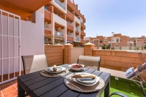 una mesa y sillas en el balcón de un apartamento en Mediterráneo Studio R&R, en Roquetas de Mar