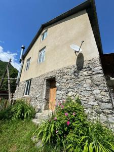 a stone house with a satellite dish on the side of it at Barbara's Eco-Cozy GuestHouse in Mestia