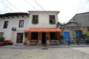un ristorante con tavoli e sedie di fronte a un edificio di Guesthouse n'Odë a Shkodër