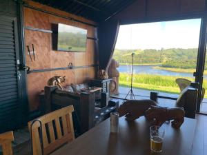 a dining room with a table with a view of a river at Villa das Cabanas in Salesópolis