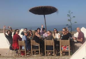 a group of people sitting at a table on the beach at Riad Sahara Sunset Beach Agadir in Douaïra