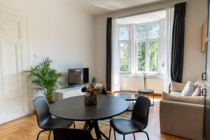 a living room with a table and chairs and a couch at Doma Zagreb Aparthotel in Zagreb