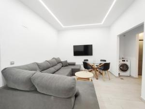 Una sala de estar con un sofá gris y una mesa. en LM14 Beach by Wave Properties, en Las Palmas de Gran Canaria