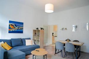 a living room with a blue couch and a table at Ruhige Wohnung nähe U Bahn Free Parking in Vienna