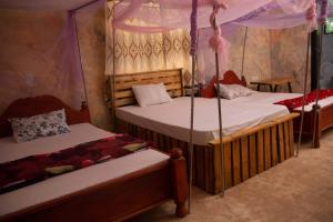 two beds in a room with a tent at Kilibase Hotel in Moshi +58 photos