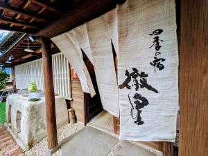 una tenda con scritte asiatiche sul lato di un patio di 四季の宿 徹星 a Tokoname