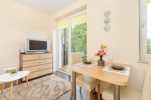 a dining room with a table and a tv at Wakacyjny Apartament z Parkingiem 500 m od Plaży by Noclegi Renters in Puck