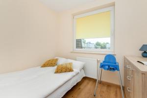 a small bedroom with a bed and a window at Wakacyjny Apartament z Parkingiem 500 m od Plaży by Noclegi Renters in Puck