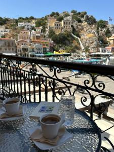 een tafel met twee kopjes koffie op een balkon bij Amorosa House in Symi