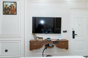 Habitación con TV en la pared y mesa. en Homes Villa (V3k08 ), en Cái Rồng