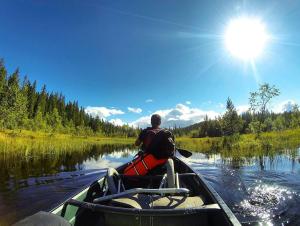 a man is in a canoe on a river at Hardanger Camping Allhovden Mountain & fjord in Norheimsund