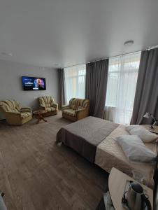 a hotel room with a bed and chairs and a tv at Sanatoriy Samara in Samarske Village