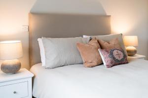 a bedroom with a bed with pillows and two lamps at No.3 Mill Park a luxury self-catering apartment in Donegal +29 photos