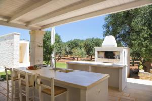 cocina al aire libre con fogones y mesa en TD Villa Ricchiari Traditional Villa with Designer Pool, en Montalbano