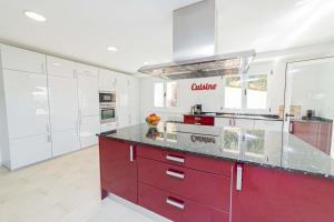 a kitchen with red cabinets and white appliances at Villa Garau / Heura 8 in Alcudia