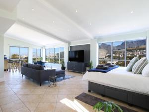 Un dormitorio con una cama grande y una sala de estar. en Ocean View Properties - Penthouse, en Ciudad del Cabo