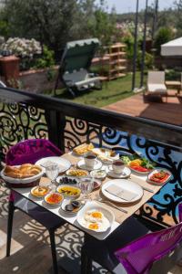 a table with plates of food on a balcony at Cunda EYE in Cunda