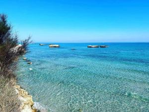 a beach with rocks in the middle of the ocean at STELLA SUL MARE in San Foca