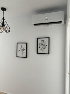 three framed pictures on a white wall at Apartamento Alto Castillo, centro histórico con garaje y WiFi in Sanlúcar de Barrameda