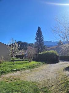 a dirt road in a yard with trees and bushes at La Maison JAUNE in Die +4 photos
