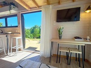 a room with a table and a tv and a window at Peneda-Gerês - Nature Pool - Garden - Parking free in Sabadim