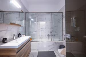 a bathroom with a shower and a sink and a glass shower stall at Hotel Iosifina, 80 metres from Episkopi beach! in Dhrámia