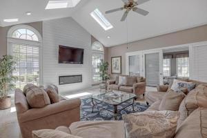 a large living room with couches and a tv at Club Views - Pool Home in Ponte Vedra Beach