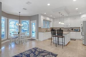 a kitchen with white cabinets and a table and chairs at Club Views - Pool Home in Ponte Vedra Beach