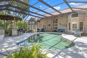 a patio with a pool and a house at Club Views - Pool Home in Ponte Vedra Beach