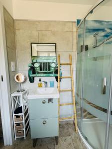a bathroom with a sink and a ladder and a car on the wall at Maison vue mer 4 personnes in Arromanches-les-Bains
